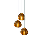 Larger view of three amber glass heads hanging on this Clérachic pendant, with pale cords leading up to the ceiling.