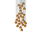A full cluster of amber glass heads on this Clérachic pendant hangs in a tapering mass from cords on a plain white background.