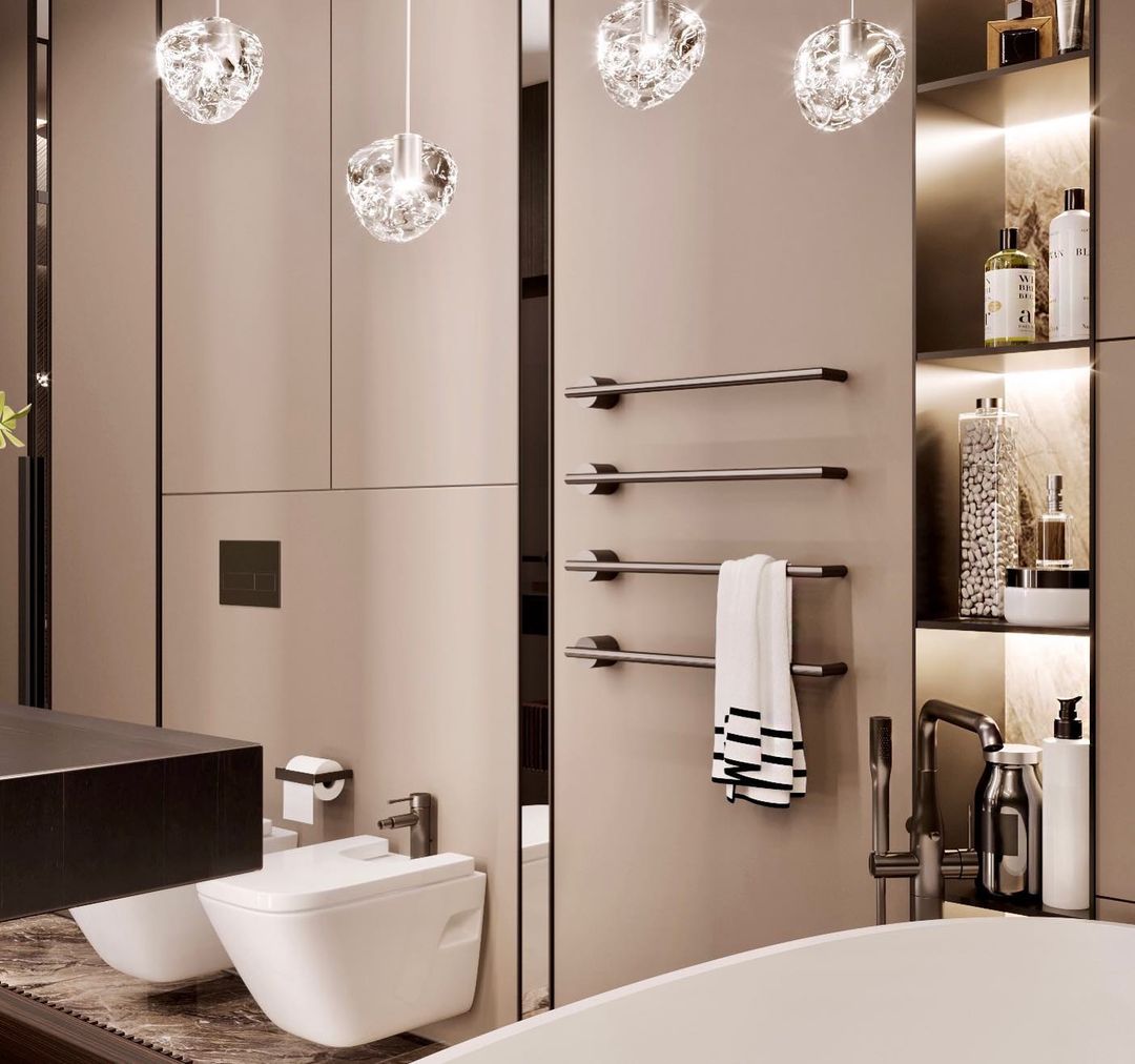 In a beige bathroom with a heated towel rail, this Clérachic pendant's clear glass heads hang at the top of the frame.