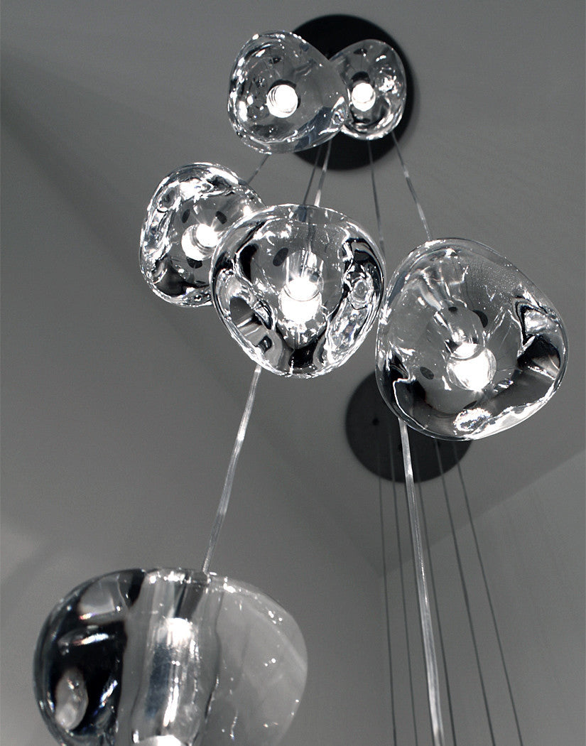From below, a tight group of clear glass heads on this Clérachic pendant rises towards a round black canopy.