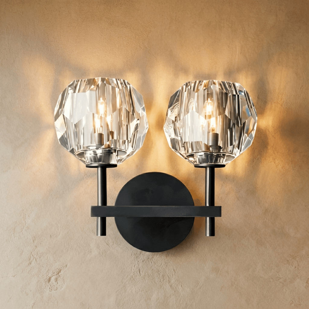 Clérachic two-head black wall sconce, twin faceted crystal shades lit warm on a crossbar and round plate.