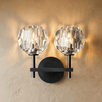 Clérachic two-head black wall sconce, twin faceted crystal shades lit warm on a crossbar and round plate.