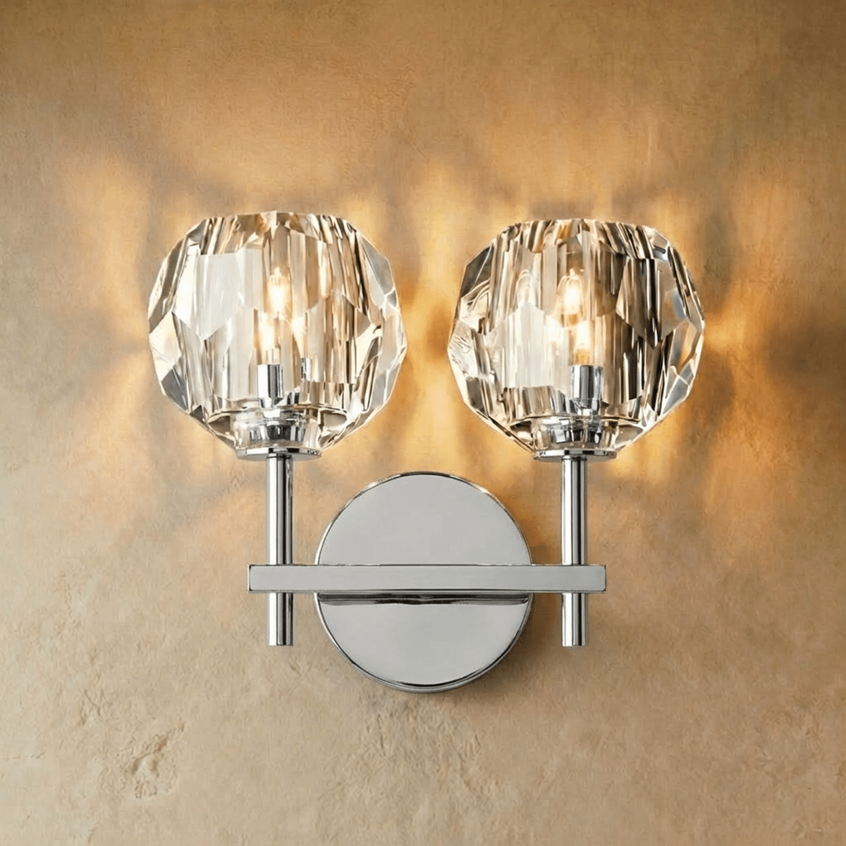 Clérachic two-head silver wall sconce, twin faceted crystal shades lit on a polished crossbar and round plate.