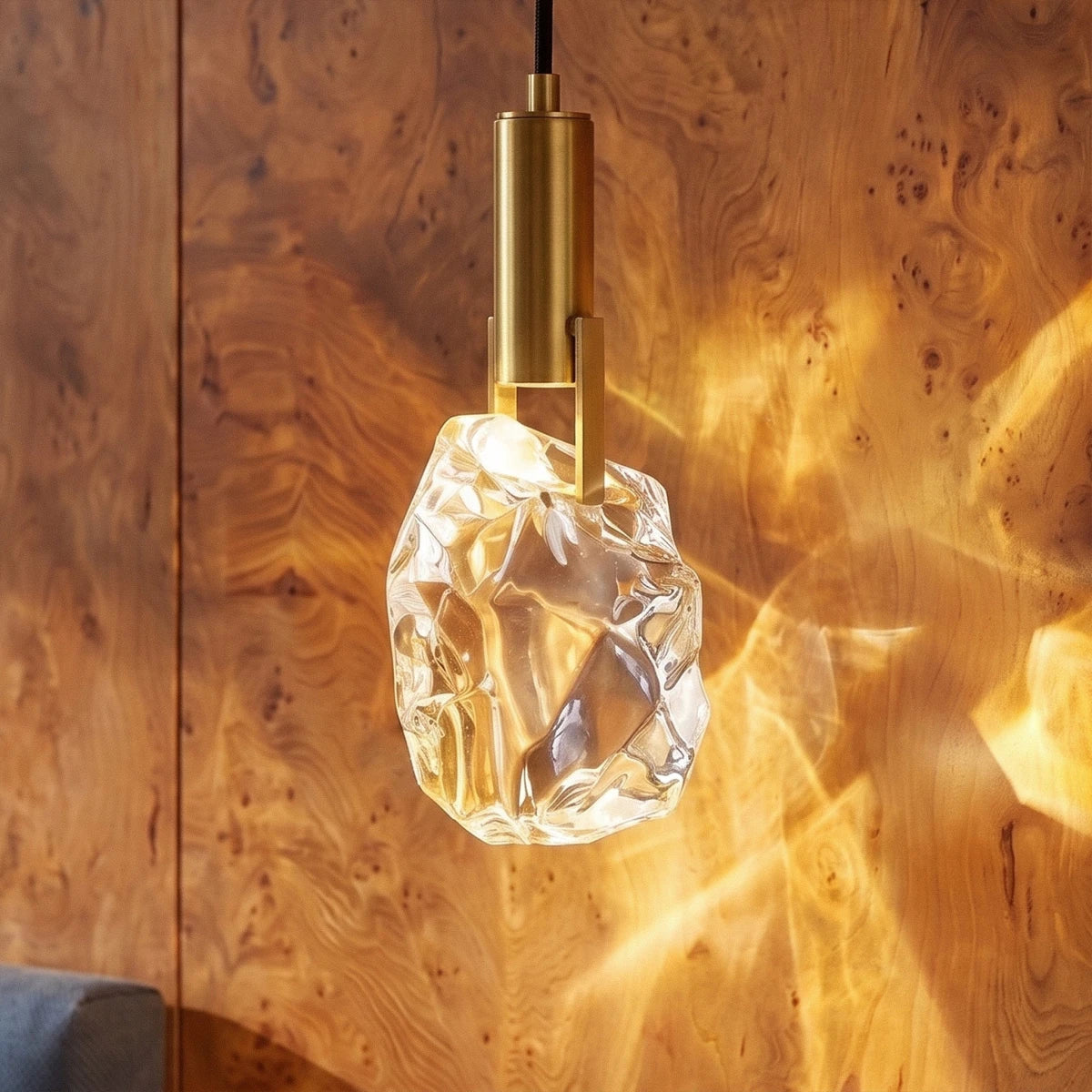 Close-up of the Clérachic crystal wall sconce's faceted glass stone glowing warm against a burl wood wall.