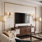 Twin-arm Clérachic wall lights with alabaster shades either side of a wall-mounted television in a cream living room.
