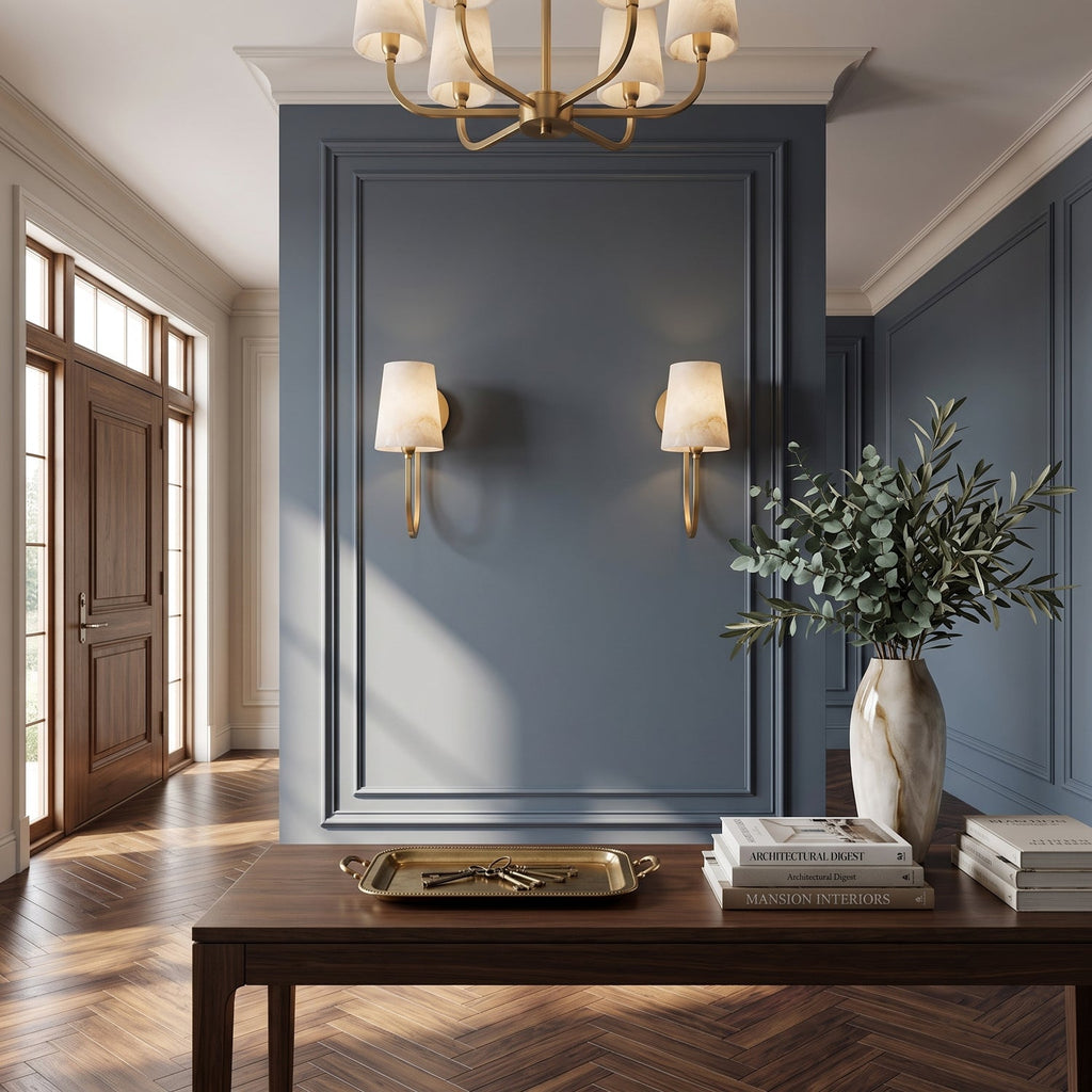 Pair of single-light Clérachic sconces on a blue panelled wall above a dark console table, with an olive branch in a vase.