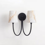 Two-light black sconce from Clérachic, its alabaster shades showing amber veining above two looped black arms.
