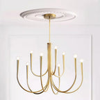 Brass-toned Clérachic chandelier under a carved white ceiling rose, with arms curving out and up to bare bulbs.