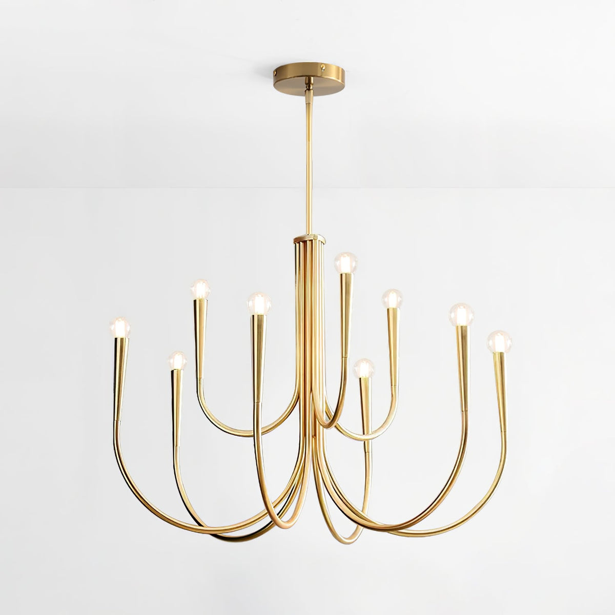 Another view of the brass-toned Clérachic chandelier on a plain pale backdrop, with its arms in two tiers and a round ceiling plate.