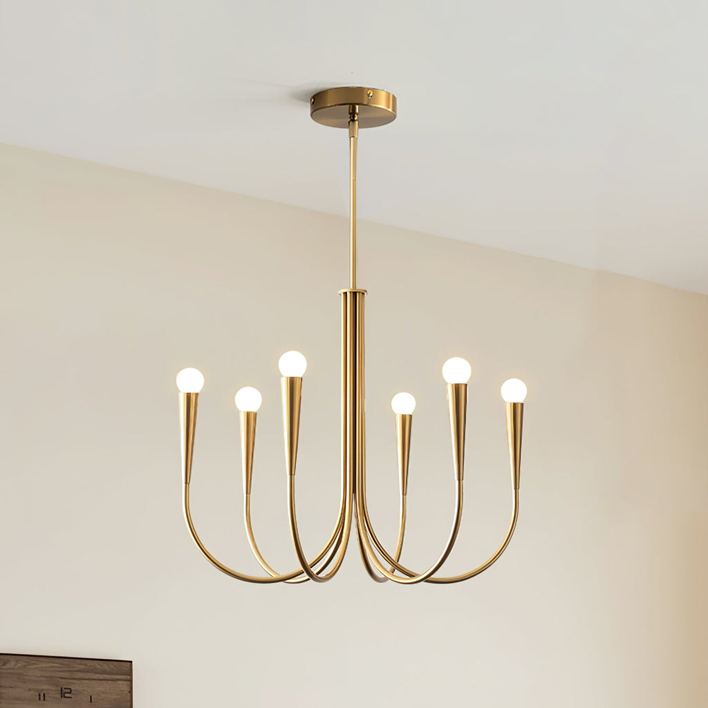 Brass-toned Clérachic chandelier with six arms and a rod, hung against a cream wall with the corner of a wooden frame below.