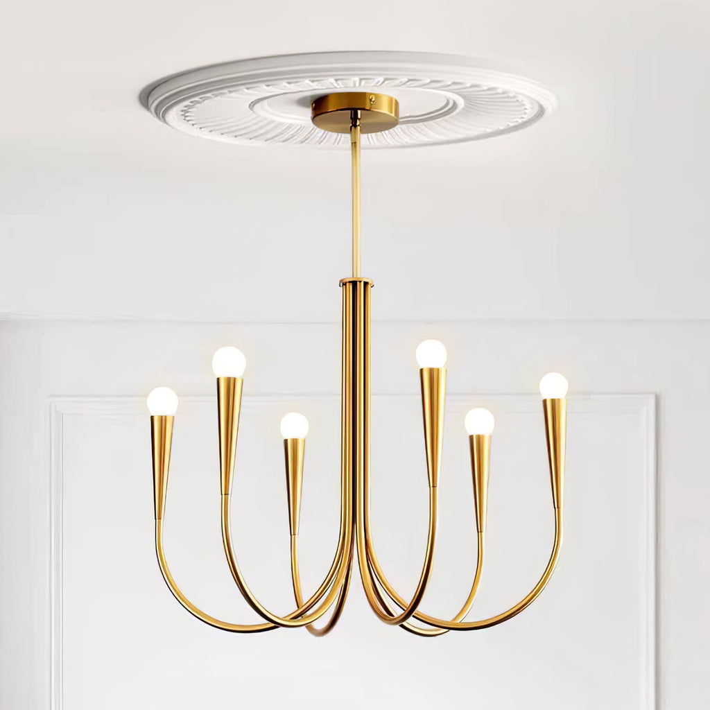 Brass-toned Clérachic chandelier with conical sockets under a plaster ceiling rose, on a white panelled wall.