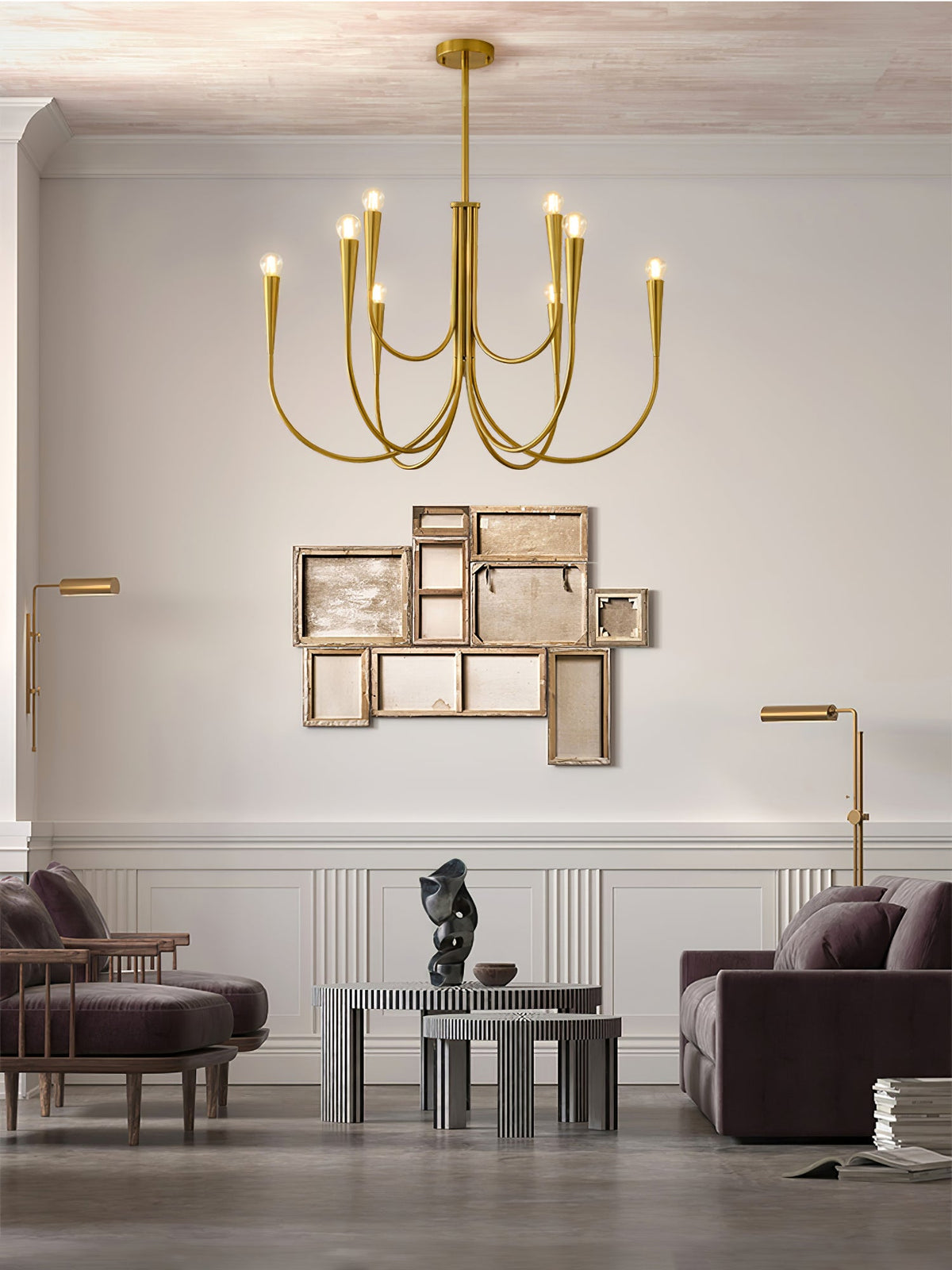A brass-toned Clérachic chandelier in a living room with a purple sofa, a gold-framed wall piece and a pair of floor lamps.