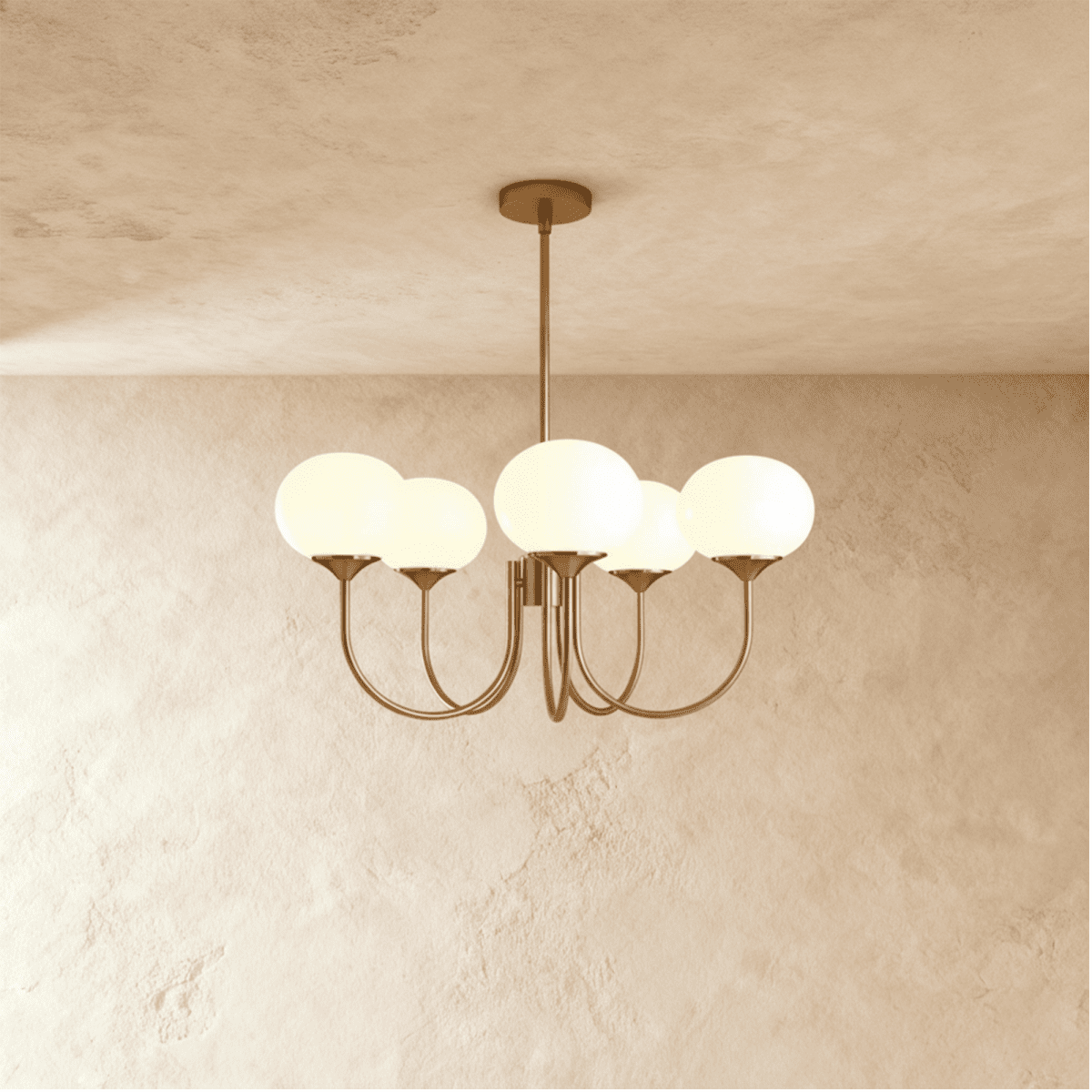 Clérachic five-light chandelier with oval white glass shades on sweeping curved arms in a soft bronze tone, lit on a limewash wall.