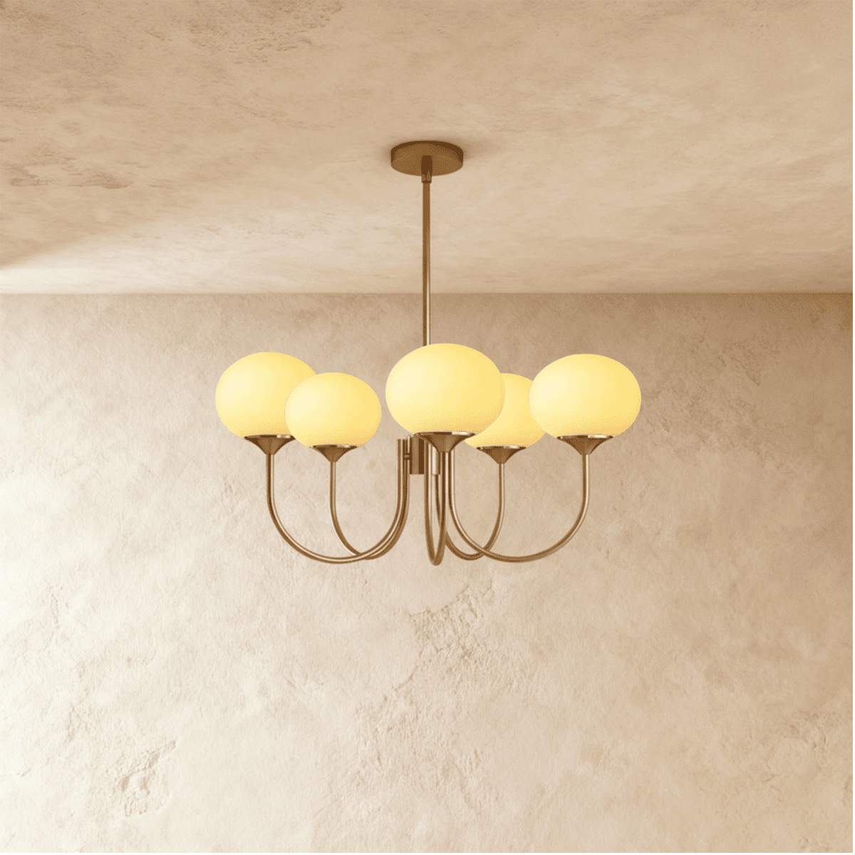 Clérachic five-light chandelier with oval cream-yellow glass shades lit warm on curved bronze-toned arms and a ceiling rod.