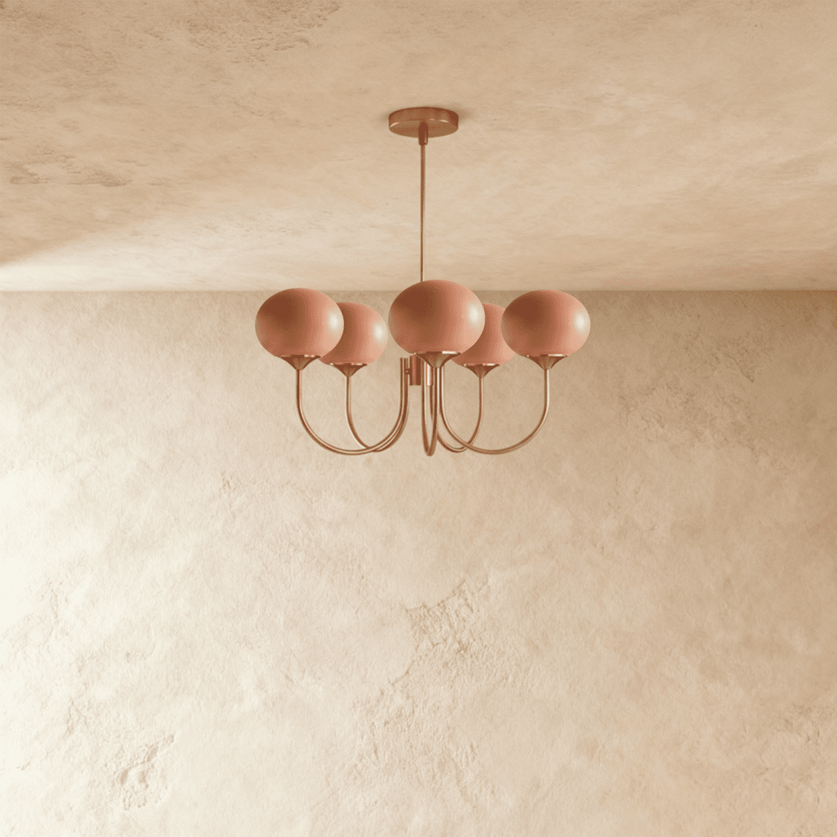 Clérachic five-light chandelier with coral-pink oval glass shades on curved copper-toned arms against a limewash wall.