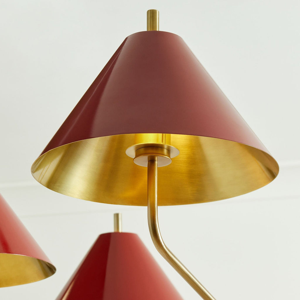Looking up into the red metal shade of this Clérachic wall light, its gold inner surface and short arm visible against a white wall.
