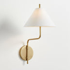 Clérachic wall light with a white fabric shade, a bent gold arm and a round gold backplate, on a plain white wall.