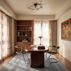 Clérachic black ceiling light with curved arms and clear glass shades above a walnut table in a calm, bright study.