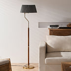 Unlit Clérachic floor lamp with a dark grey pleated shade, standing beside a cream armchair and a wooden console.