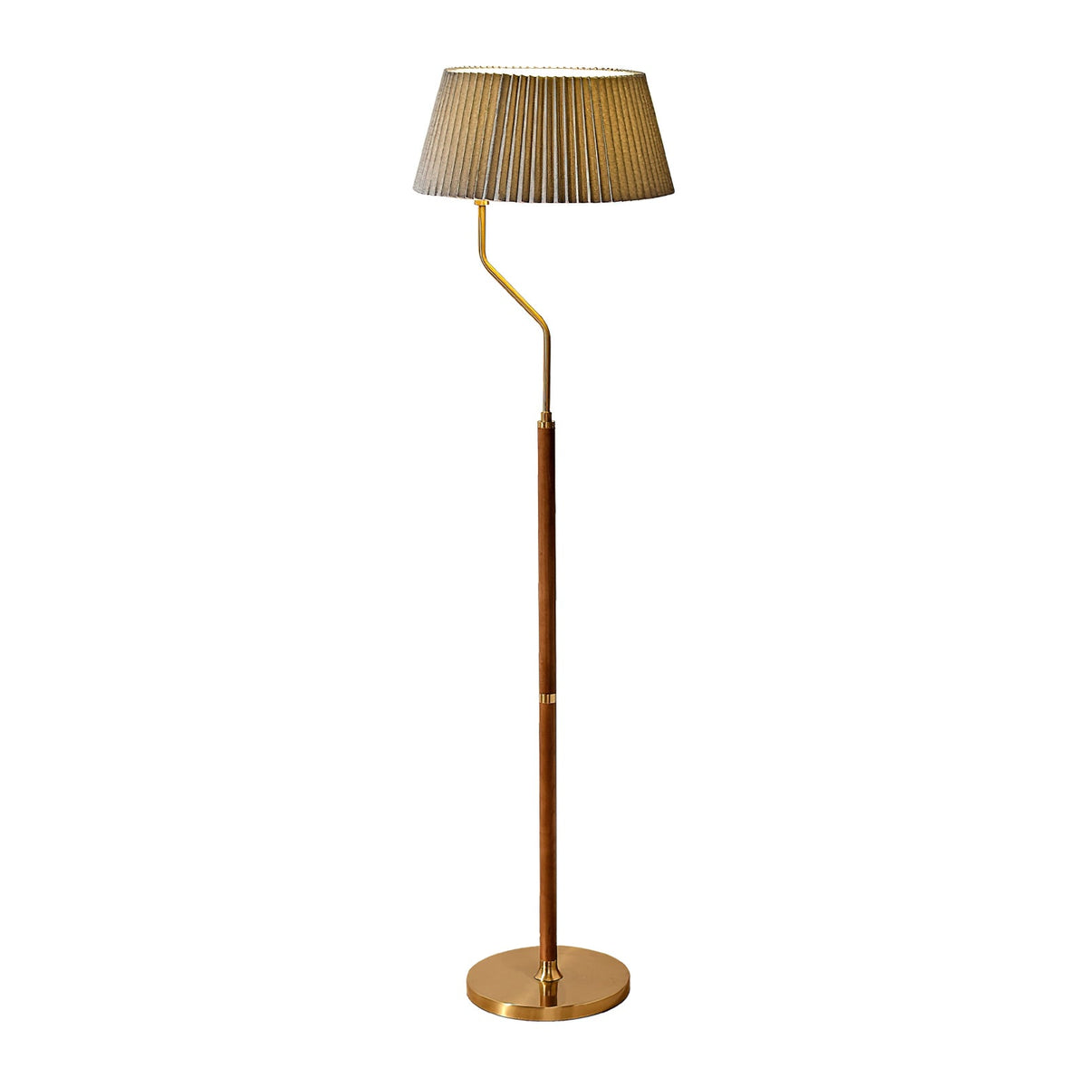 Studio view of a Clérachic floor lamp with a grey-green pleated shade, a curved brass arm and walnut stem, on white.