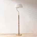 Full-length view of this Clérachic floor lamp with a white pleated shade and walnut stem, against a plain wall.