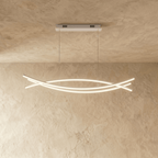 Clérachic long LED chandelier with three crossing curved light bars hung on thin cords from a rectangular canopy, lit warm.