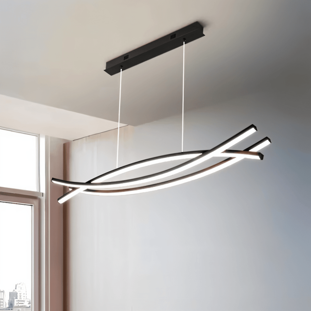 Clérachic black crossing-bar LED chandelier on a black canopy, glowing in a bright room beside a tall window.