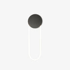 This Clérachic wall light on a plain white backdrop, with a matte black round disc at the top and a slim white LED loop hanging below it.