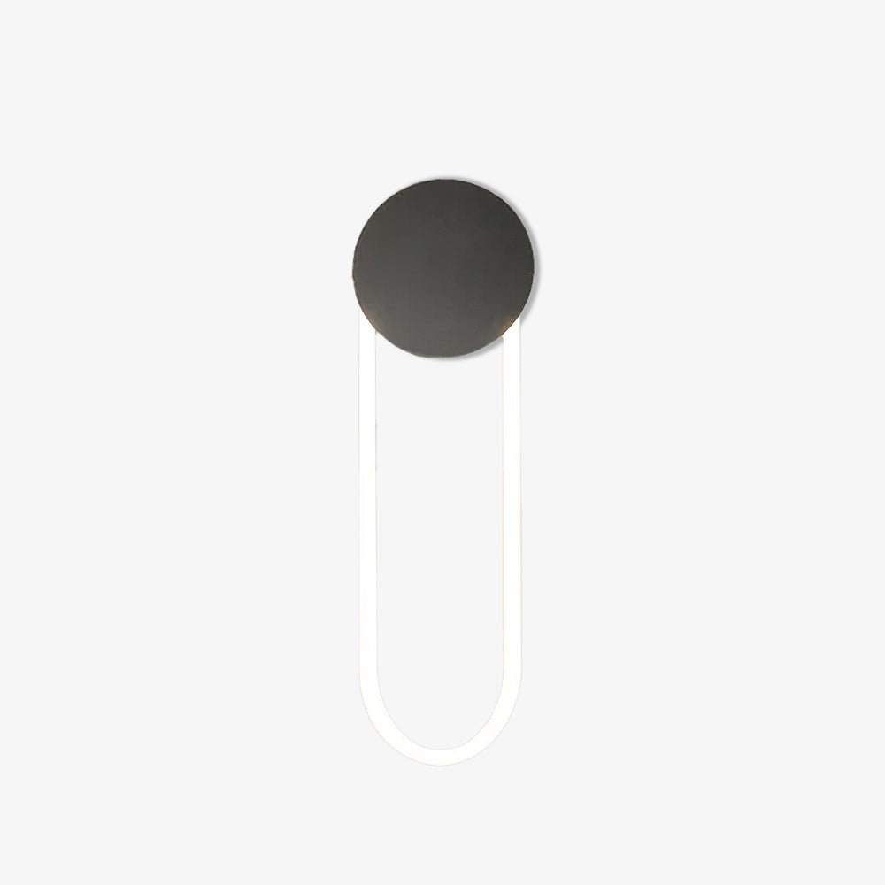 This Clérachic wall light on a plain white backdrop, with a matte black round disc at the top and a slim white LED loop hanging below it.