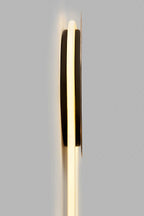 Edge-on view of this Clérachic wall light, showing the thin black disc mounting and the warm glow of the LED loop behind it.