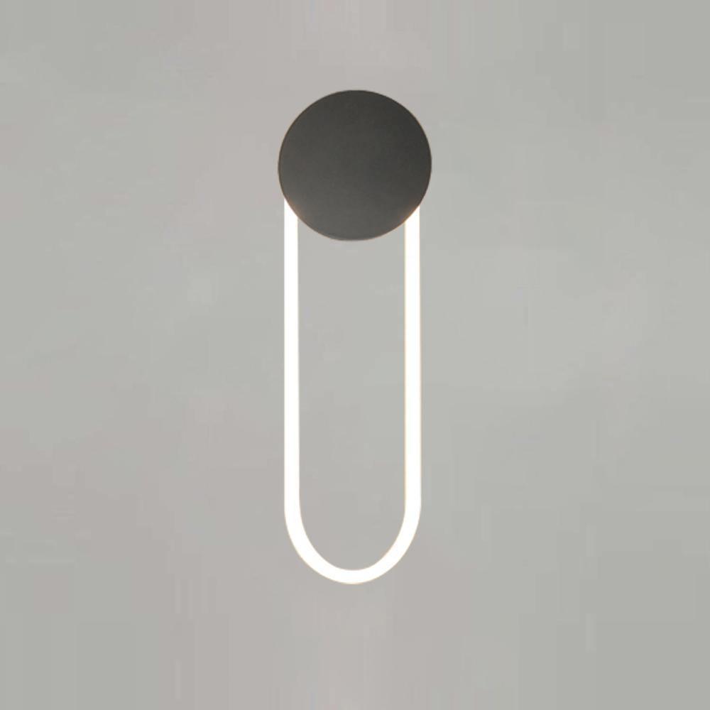 Front view of this Clérachic wall light on a soft grey backdrop, with a matte black disc and a white LED loop lit cool white.