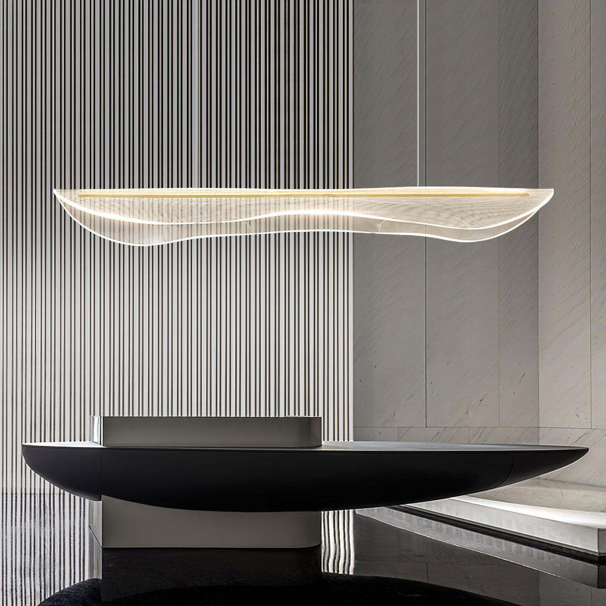 This Clérachic pendant light over a black sculptural console, with a ribbed grey wall behind its slim, wavy acrylic shade.