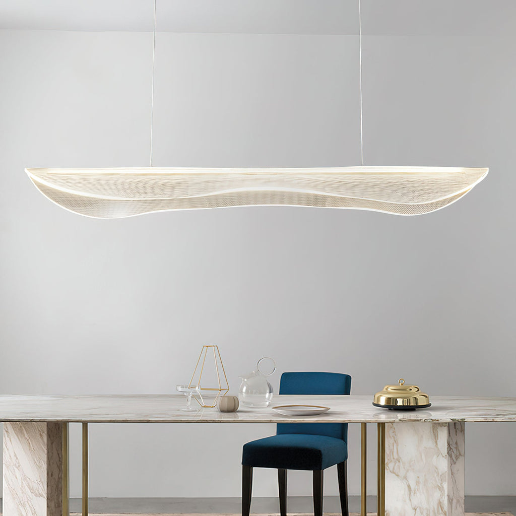 Clérachic wavy acrylic pendant hanging above a marble table with brass legs, a blue chair and a glass vase on a pale grey wall.