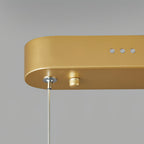 Close view of the gold canopy end on this Clérachic pendant light, with three small vents, a cable grip and the thin suspension wire.