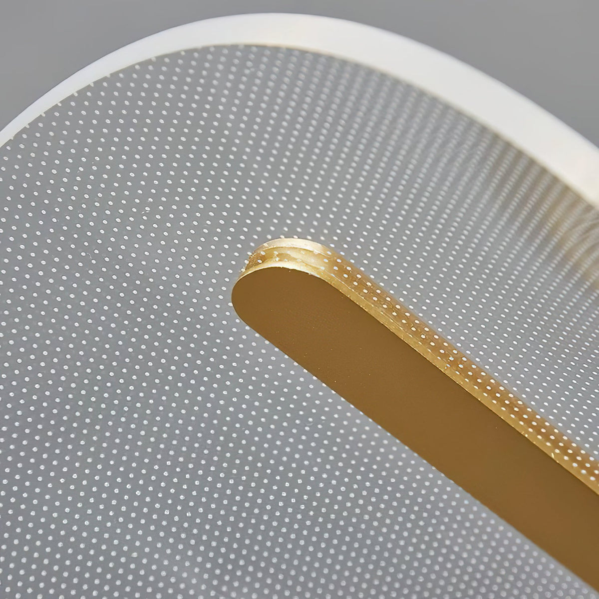 Close view from below of the gold bar and the dotted clear acrylic panel on this Clérachic pendant light.