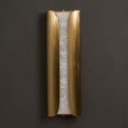 Front view of the unlit Clérachic wall sconce, with two curved brass panels either side of a pale veined alabaster slab.