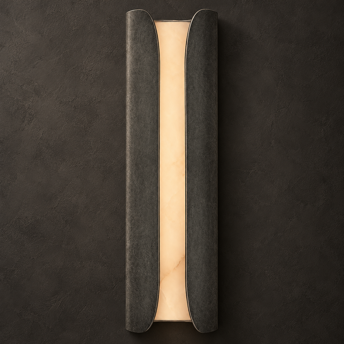 Clérachic alabaster sconce in a dark mottled pewter finish, its warm glowing stone slab framed by two curved panels.