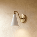 Clérachic cone-shade wall sconce in vintage brass, shown from a slightly closer studio angle on a plaster wall.