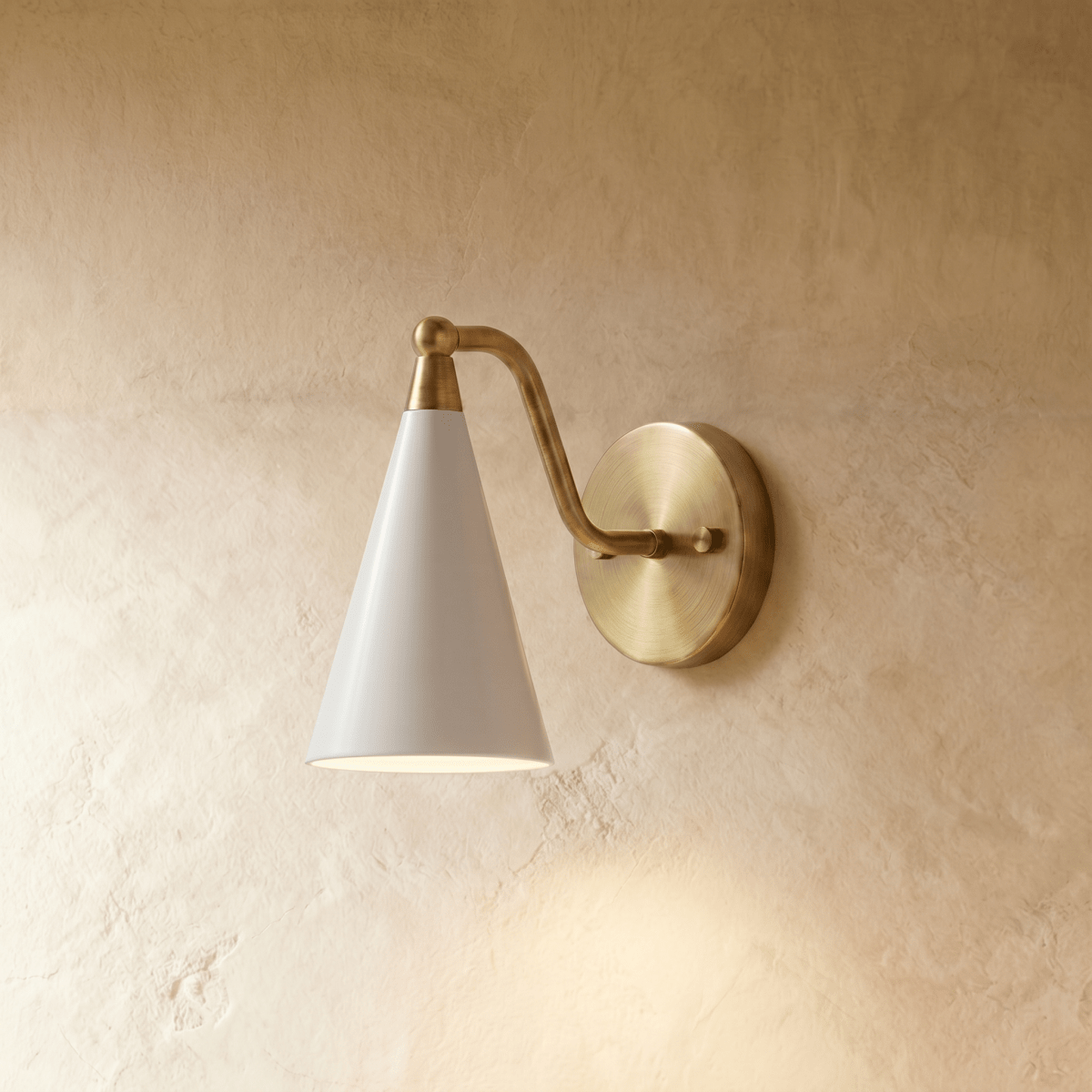 Clérachic cone-shade wall sconce in vintage brass, shown from a slightly closer studio angle on a plaster wall.