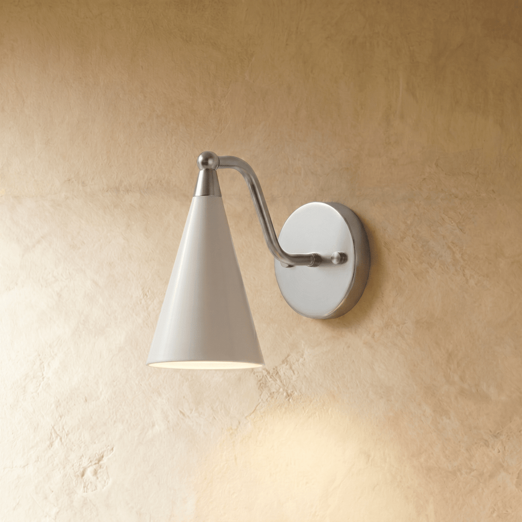 Clérachic cone-shade wall sconce in satin chrome with a white shade, mounted on a plaster wall in studio light.