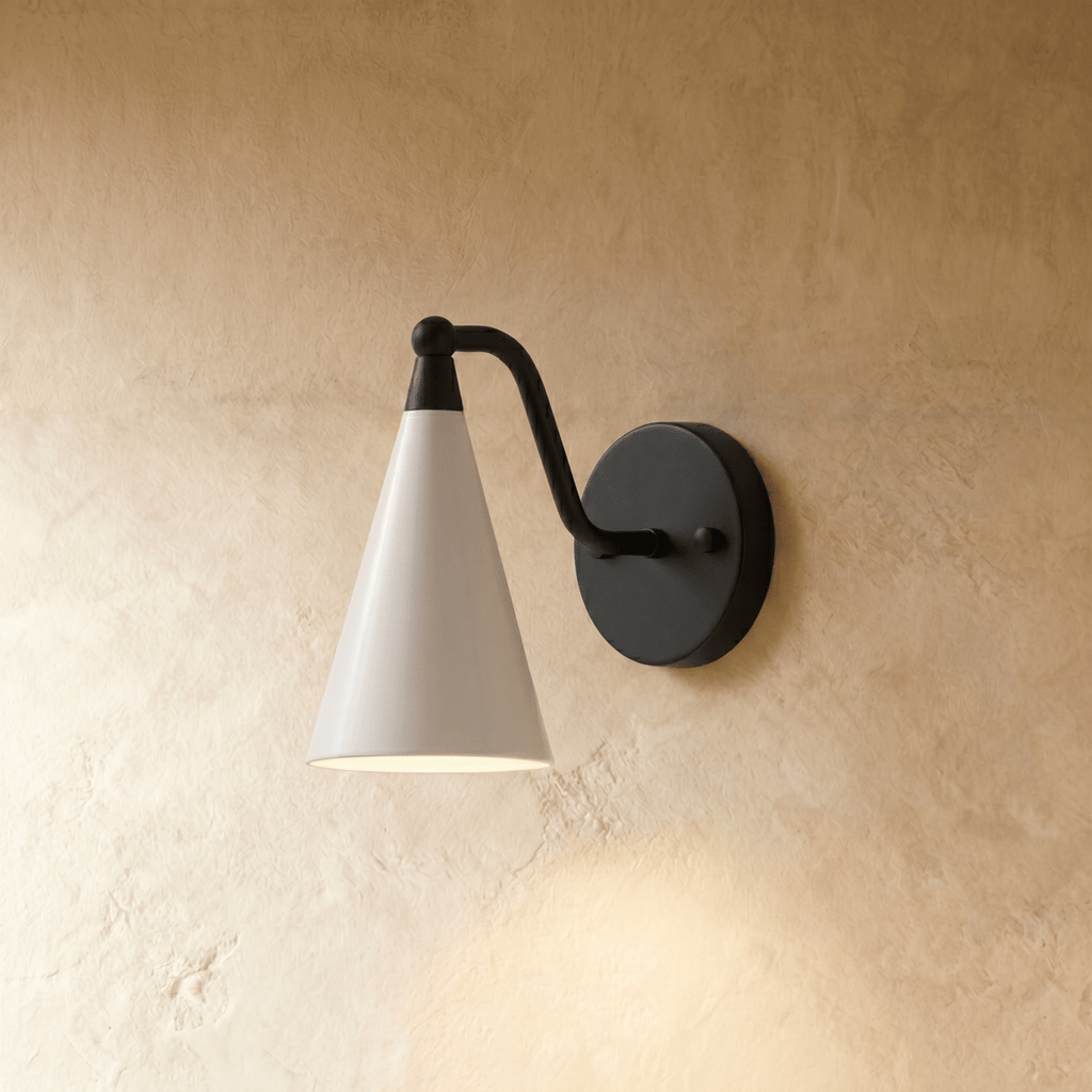 Clérachic cone-shade wall sconce in matte black with a white shade, mounted on a plaster wall in studio light.