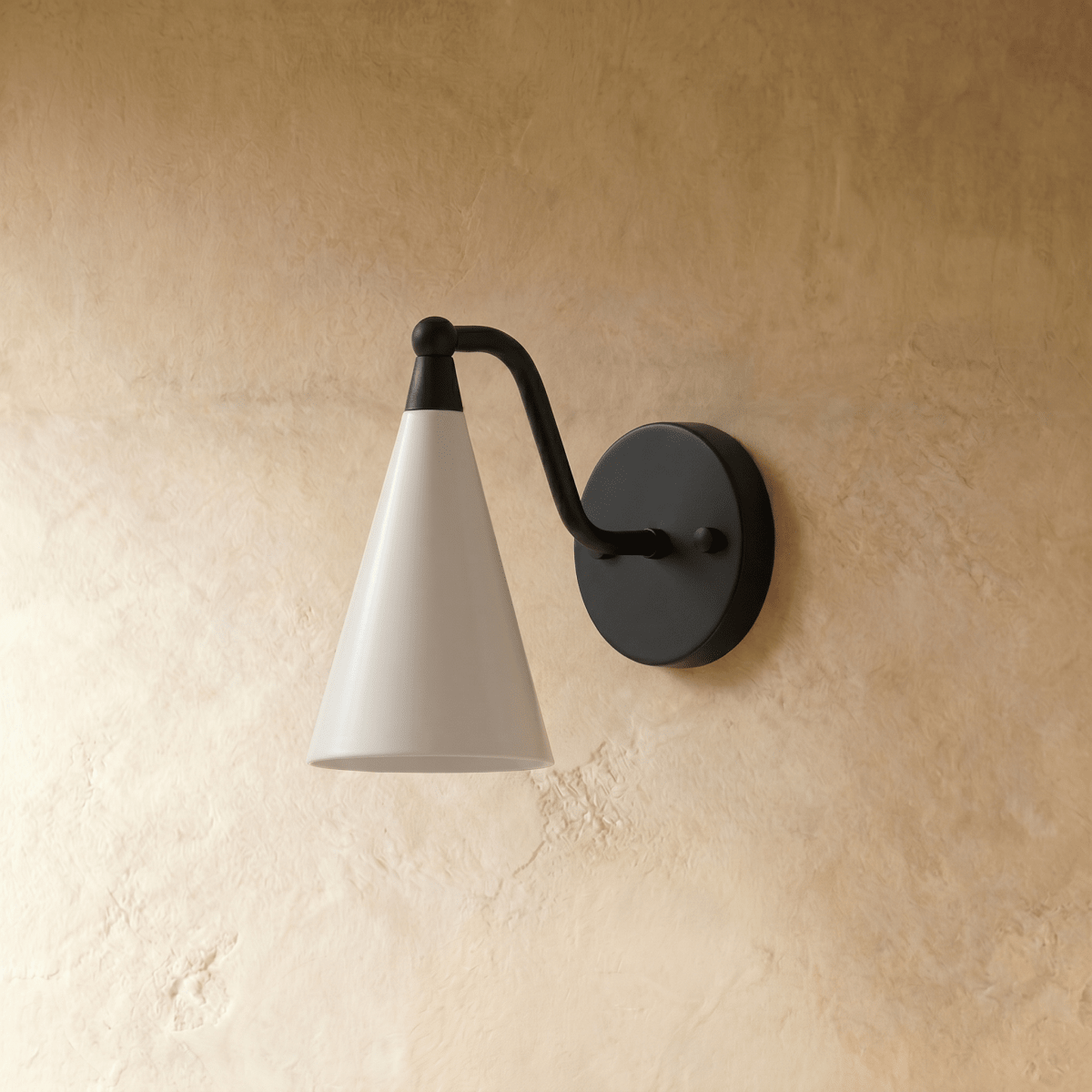 Clérachic cone-shade wall sconce in matte black, shown from a slightly closer studio angle on a plaster wall.