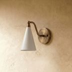 Clérachic cone-shade wall sconce in polished brass, shown from a slightly closer studio angle on a plaster wall.