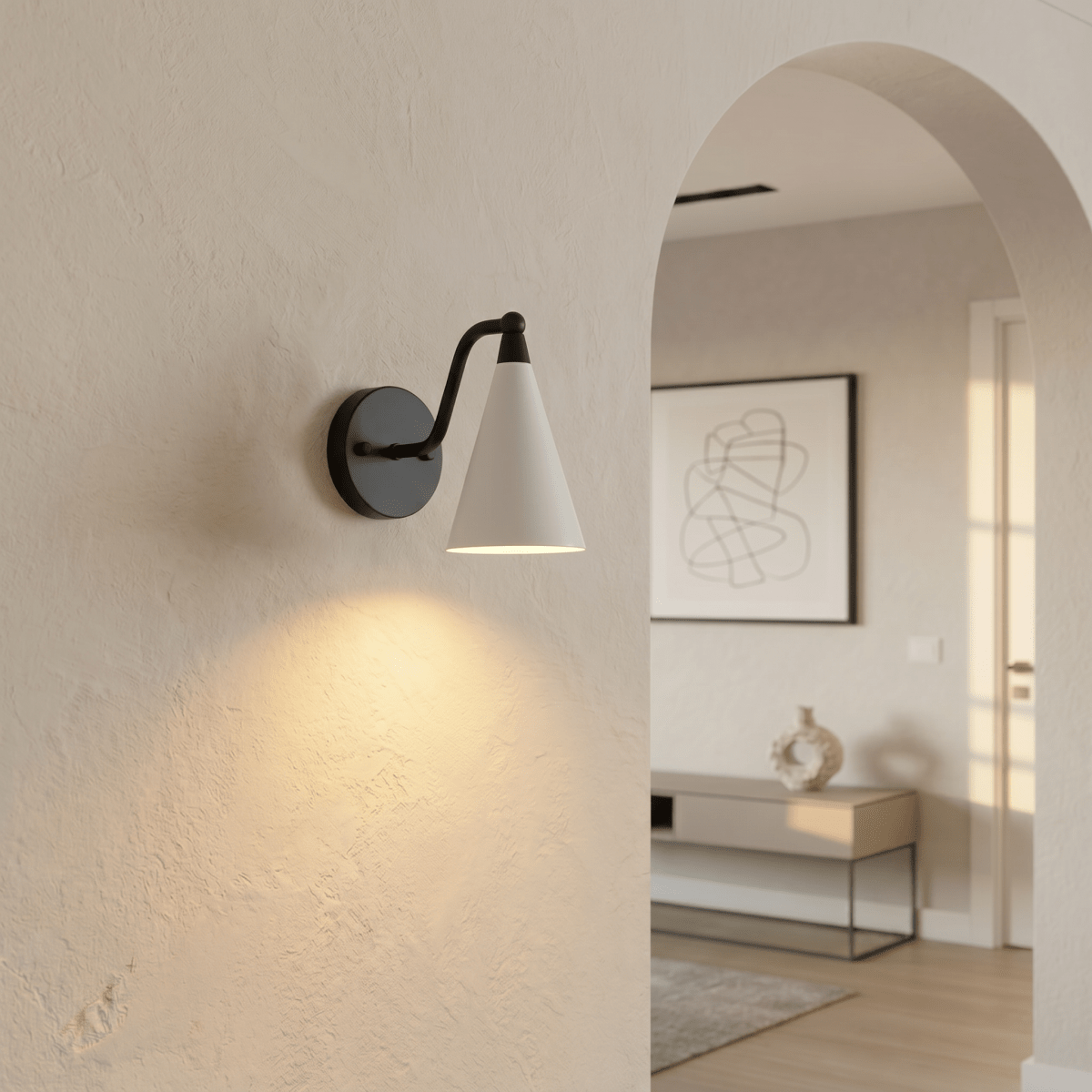 Clérachic matte black cone-shade wall sconce lit on an archway wall beside a framed abstract line print.