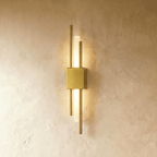A slender Clérachic wall sconce in brushed gold pairs vertical brass rods with a glowing acrylic diffuser bar.