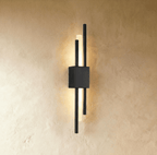 A closer view of the matte black Clérachic wall sconce, its square backplate anchoring two rods and a lit acrylic diffuser.