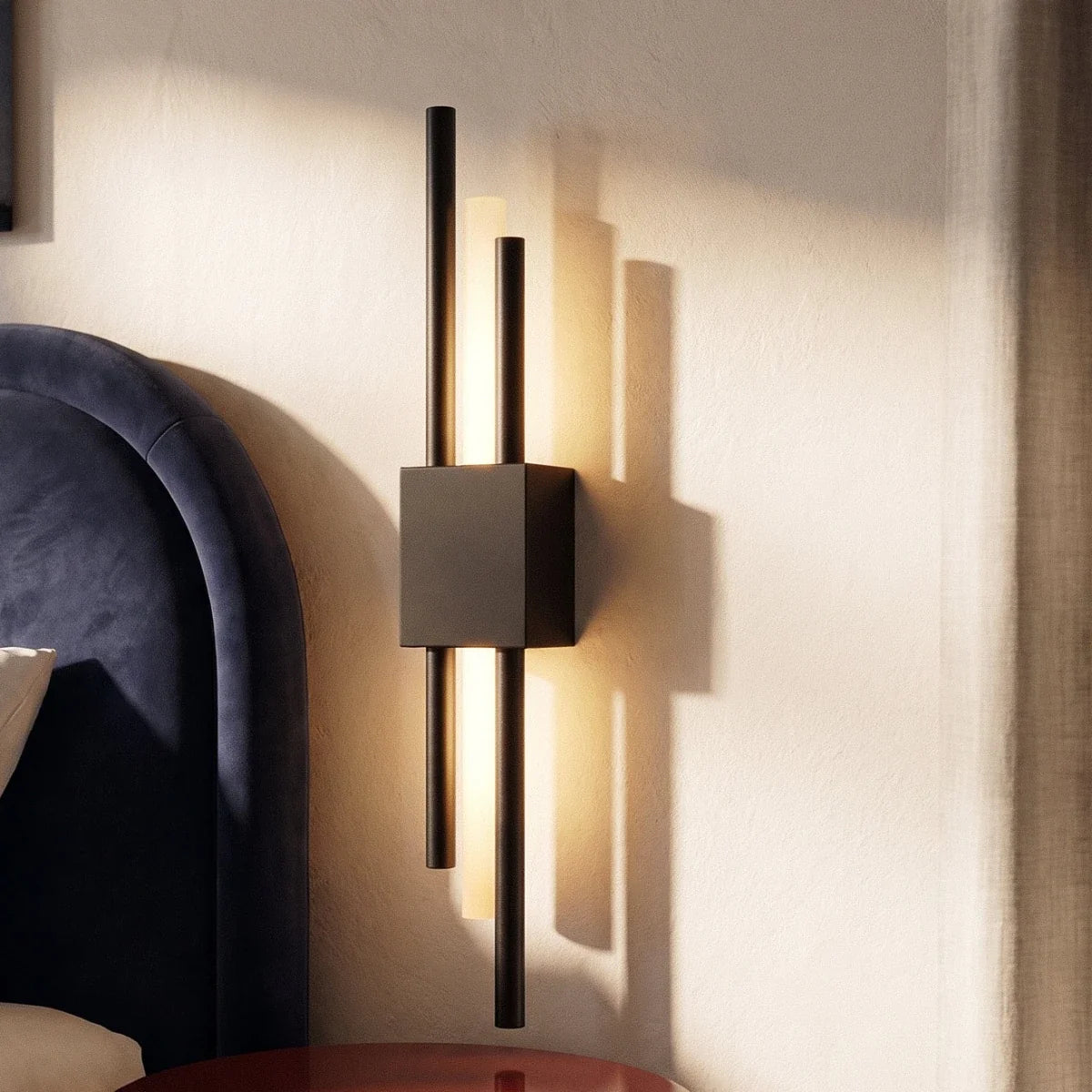 A closer look at the matte black Clérachic wall sconce beside the bed, its brass-toned rods casting linear shadows.