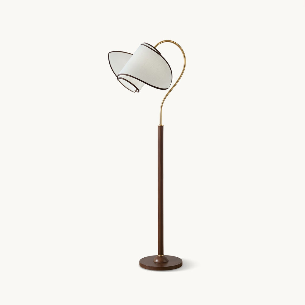 A Clérachic floor lamp with a walnut-colour stem and round base, a brass arc and a white fabric shade, on a plain white backdrop.