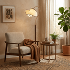 In a sunlit corner, a Clérachic floor lamp with a curved brass arm arches over a bouclé armchair and a round side table.