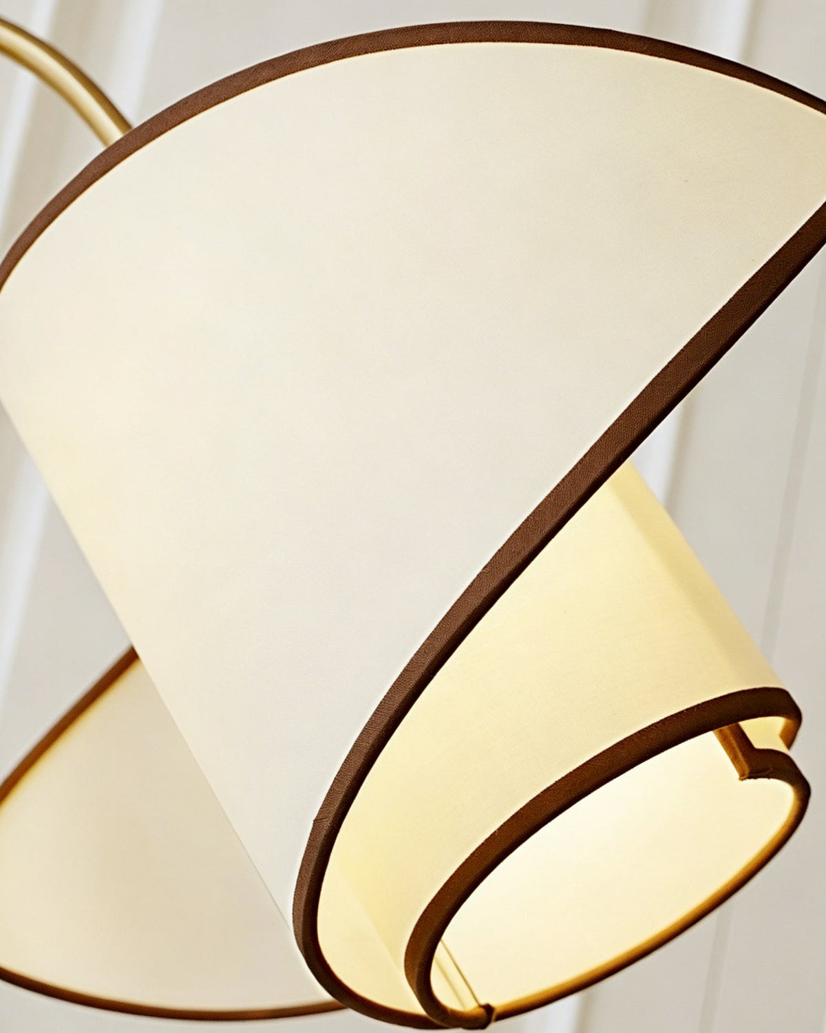 Close view of the folded white fabric shade on this Clérachic floor lamp, with its dark brown trim and warm light inside.